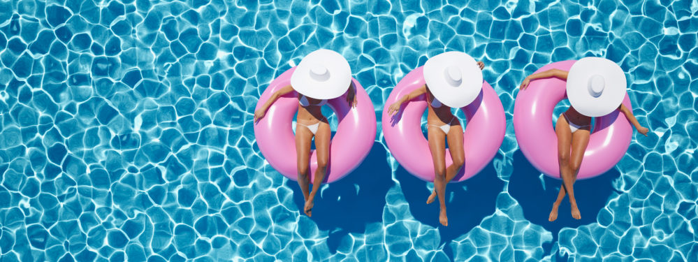 women swimming on float in a pool.